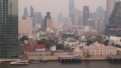 boats-going-down-the-chao-phraya-river-at-sunset-in-downtown-Bangkok,-the-capital-city-of-Thailand