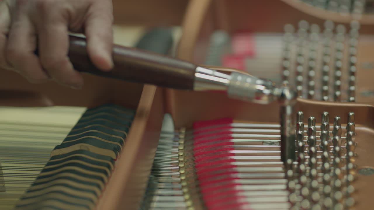A man tunes a piano with specialty tools
