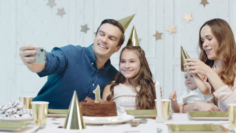 cheerful people celebrating one year birthday in party hat together.