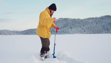 Ice-Fishing-Auger-Use-By-A-Man-In-Digging-Hole-In-Frosted-Lake