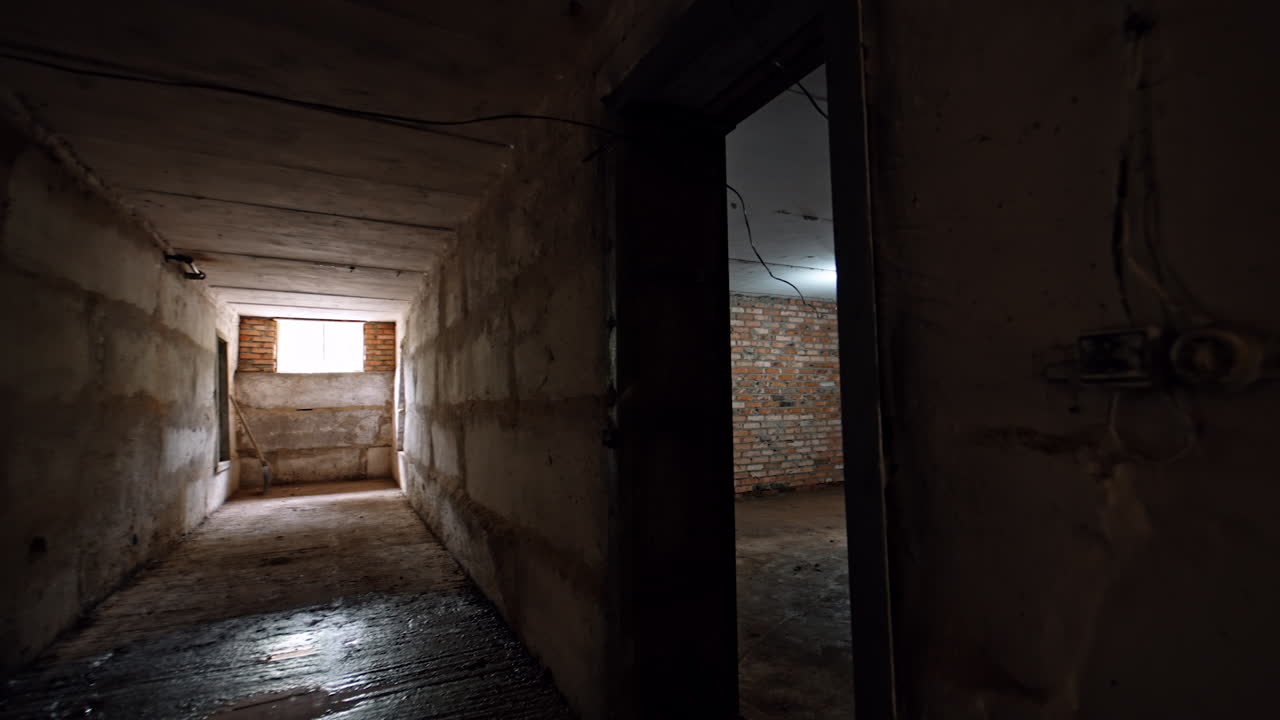 Large spacious empty premise of an old building under reconstruction. A wooden box is inside the room. Dark rooms in the basement.