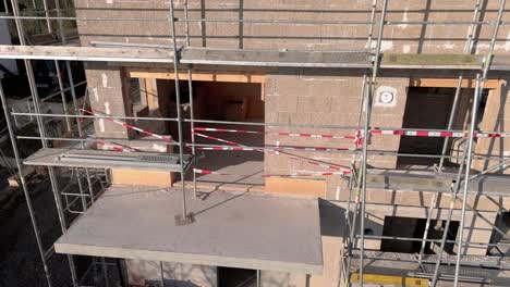 vista aérea de una casa de hormigón de cáñamo durante el sitio de construcción, en órbita lenta en la noche soleada
