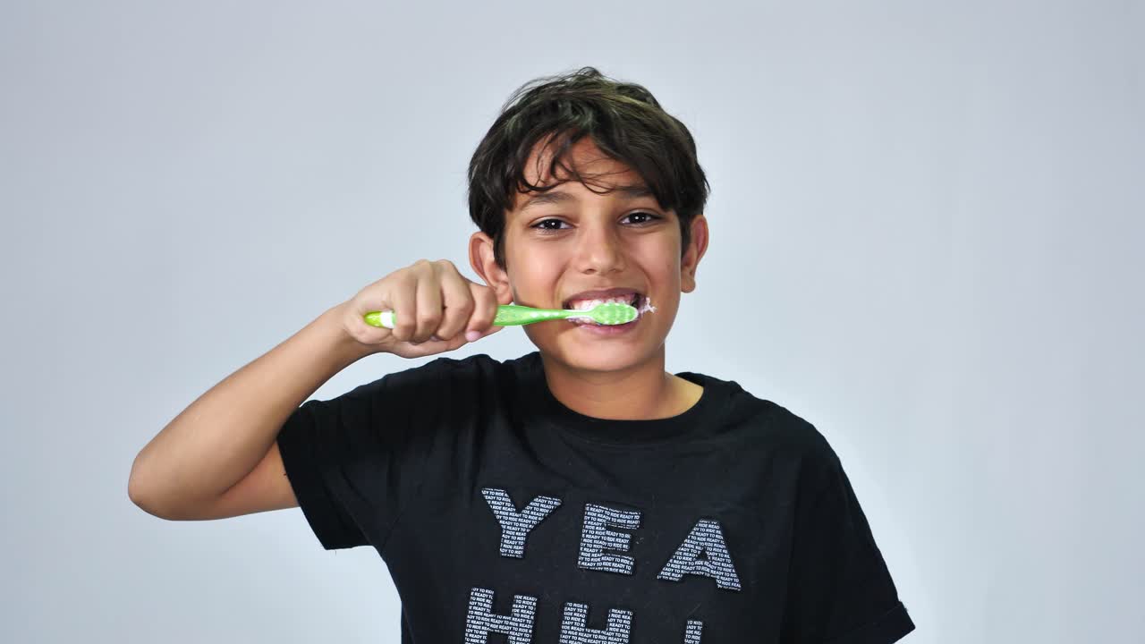 Portrait of cheerful boy washing teeth isolated on white background