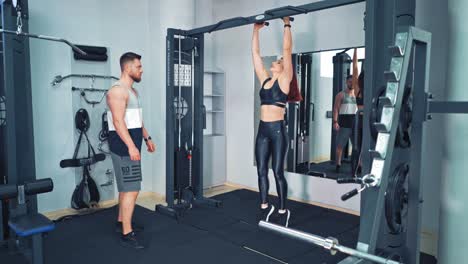couple training together in fitness center. young beautiful woman doing exercises with personal trainer