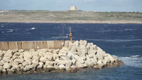 Dark-Blue-Mediterranean-Sea-Crashes-Waves-in-Breakwaters-made-from-Stone