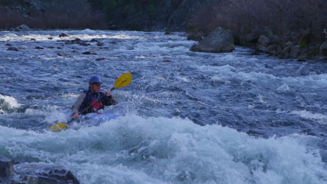 급류 급류를 통해 노를 젓는 카약 선수