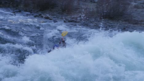 a kayaker paddles through white water rapids