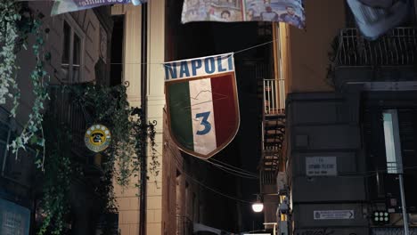 napoli football crest displayed in city alley, night scene