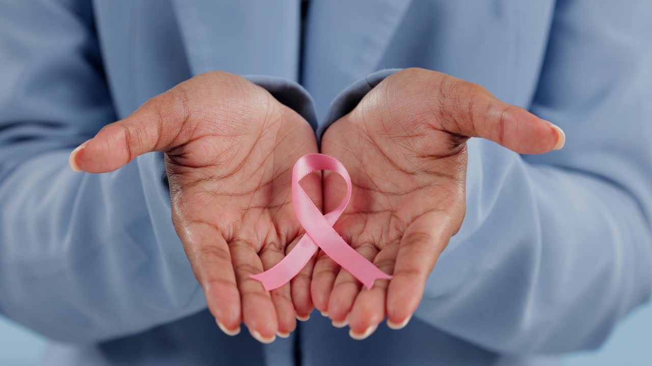 Nastro rosa, mani e donna malata di cancro