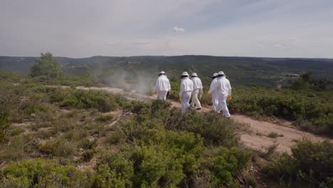 Los-Apicultores-Caminan-Hacia-La-Colmena-Entre-Arbustos-De-Romero