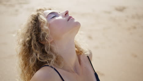 relaxed lady sitting sand seashore feeling calmness close up. woman closing eyes