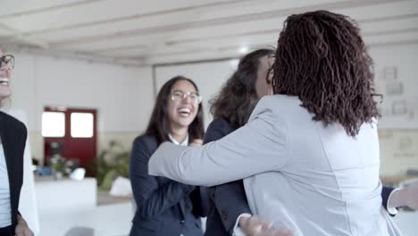 Excited-businesswomen-applauding-and-hugging