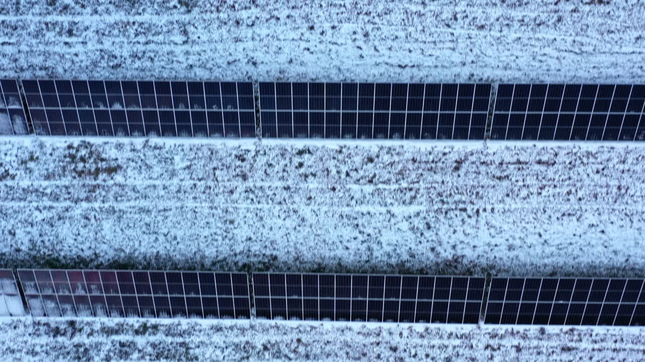 라트비아 시골의 눈 인 재생 가능한 태양 전력 농장 패널을 내려다보는 공중 풍경