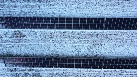 vista aérea mirando hacia abajo sobre paneles solares renovables nevados en el campo letón escena rural