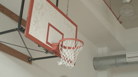 close up of a basketball going into a hoop