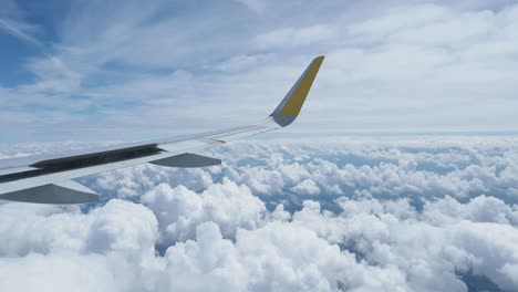 airplane wing and cloudscape view from above