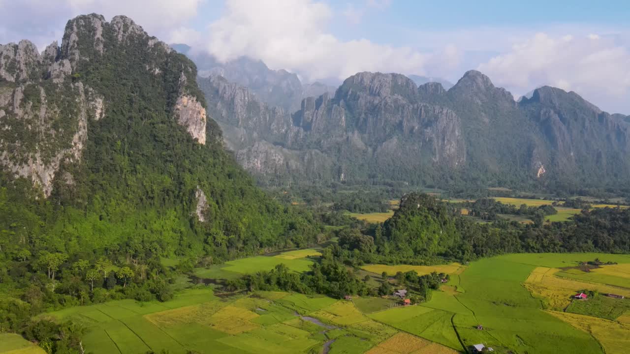 Aerial View Of Green Farming Fields With Soaring Forested Mountain Landscape At Vang Vieng