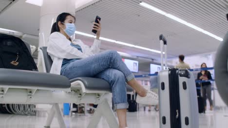 4k asian tourist women wear protective face masks for outbreak coronavirus sit on social distancing chair use smartphone for contact with friend or family. women use mobile phone with green screens.