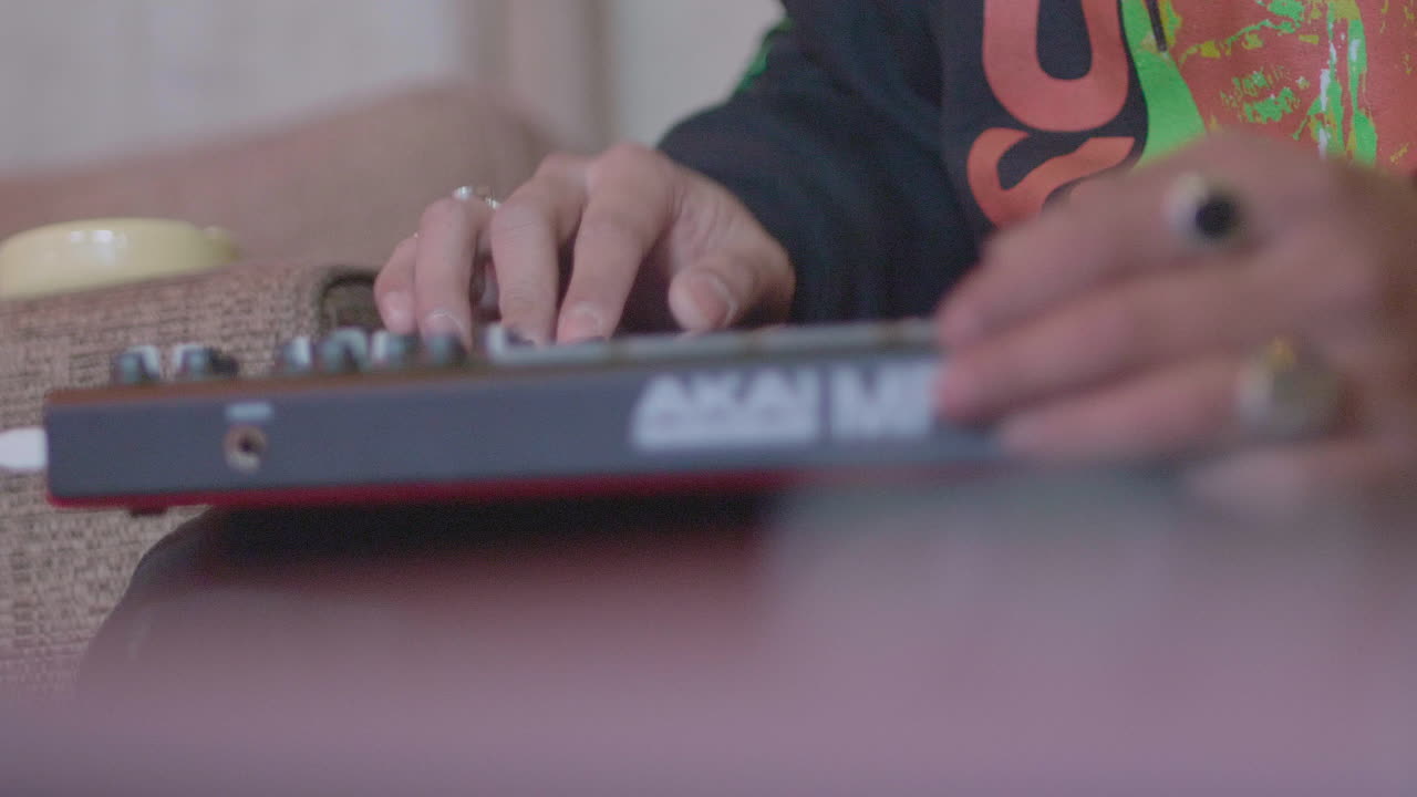 Boy playing on a mini keyboard, shifting focus to buttons on foreground
