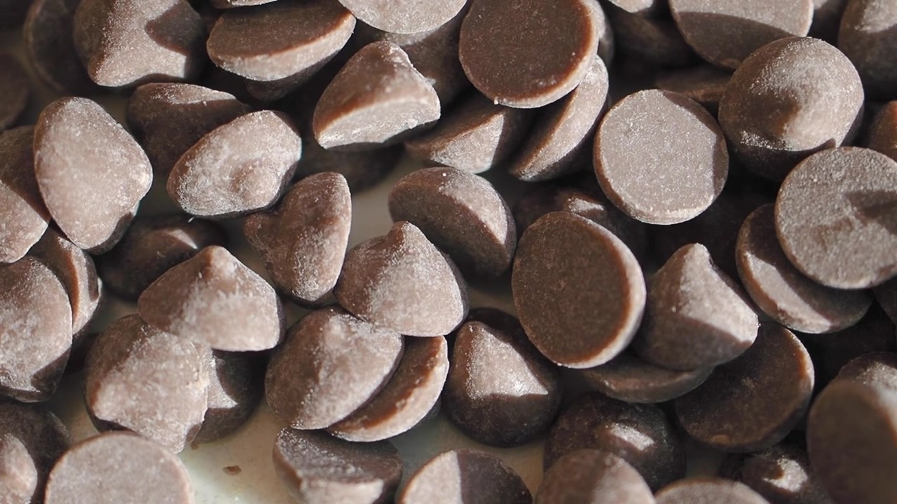 Primo piano di gocce di cioccolato che cadono su un mucchio