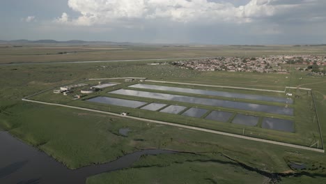 Clouds-reflect-in-water-treatment-ponds,-Villiers-South-Africa-aerial