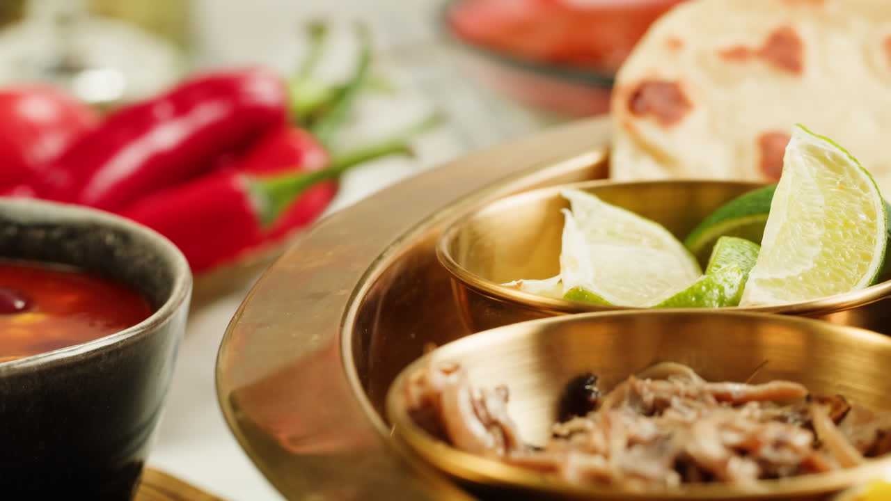 Assorted indian sri-lanka food set on wooden background. Dishes and appetisers of indeed cuisine, rice, lentils, paneer, samosa, spices, masala. Bowls and plates with indian food top view chicken. High quality 4k footage