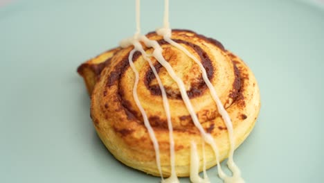 cinnamon bun pastry being drizzled with icing