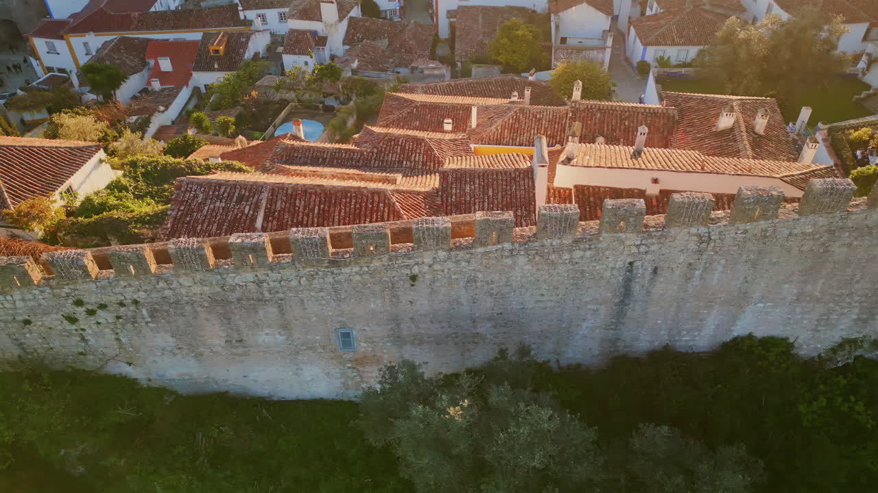 Mura medievali che attraversano la città con tetti in tegole, vista drone. Castello in pietra.