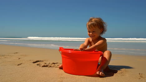 happy child playing with sand on a sunny beach