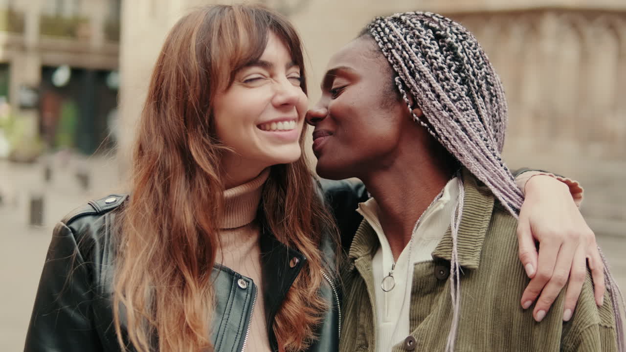 Diverse giovani donne che si scambiano affetto e sorridono all'aperto