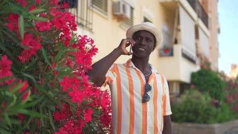 contenido negro hablando en el teléfono inteligente cerca de flores