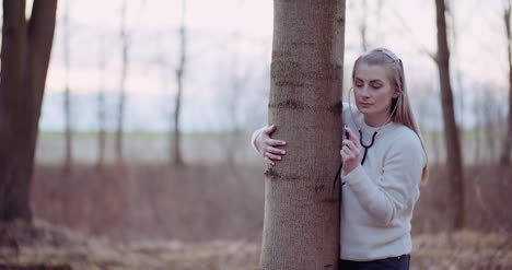 mujer usa un estetoscopio y examina un árbol en el bosque 3