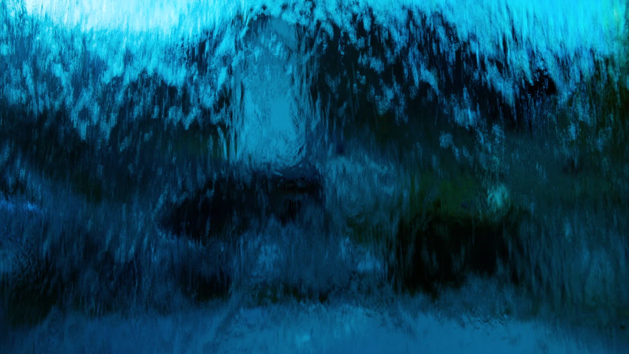 Abstract view of deep blue water flowing down over glass in front of camera view in village in Europe, wide view