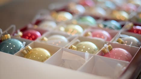 Tight-focus-on-glossy,-colorful-Christmas-baubles-in-a-box