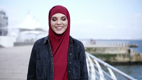 Frontside-footage-of-an-attractive-young-muslim-girl-with-stunning-colorful-smokey-eye-make-up-looking-right-at-the-camera-while-walking-near-the-sea-side