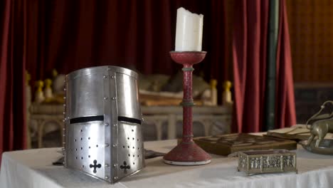 medieval knight's helmet and candle in a historical setting