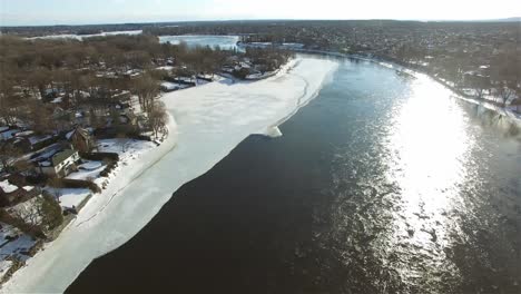 slow-moving drone shot on a sunny day over a lake with houses surrounding it