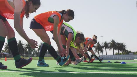 Female-hockey-players-exercising-on-the-field