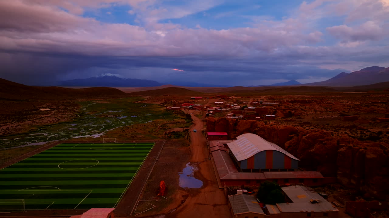 Vista aerea da drone della remota città d'alta quota di Aguas Calientes in Bolivia durante un tramonto spettacolare e colorato sulle Ande