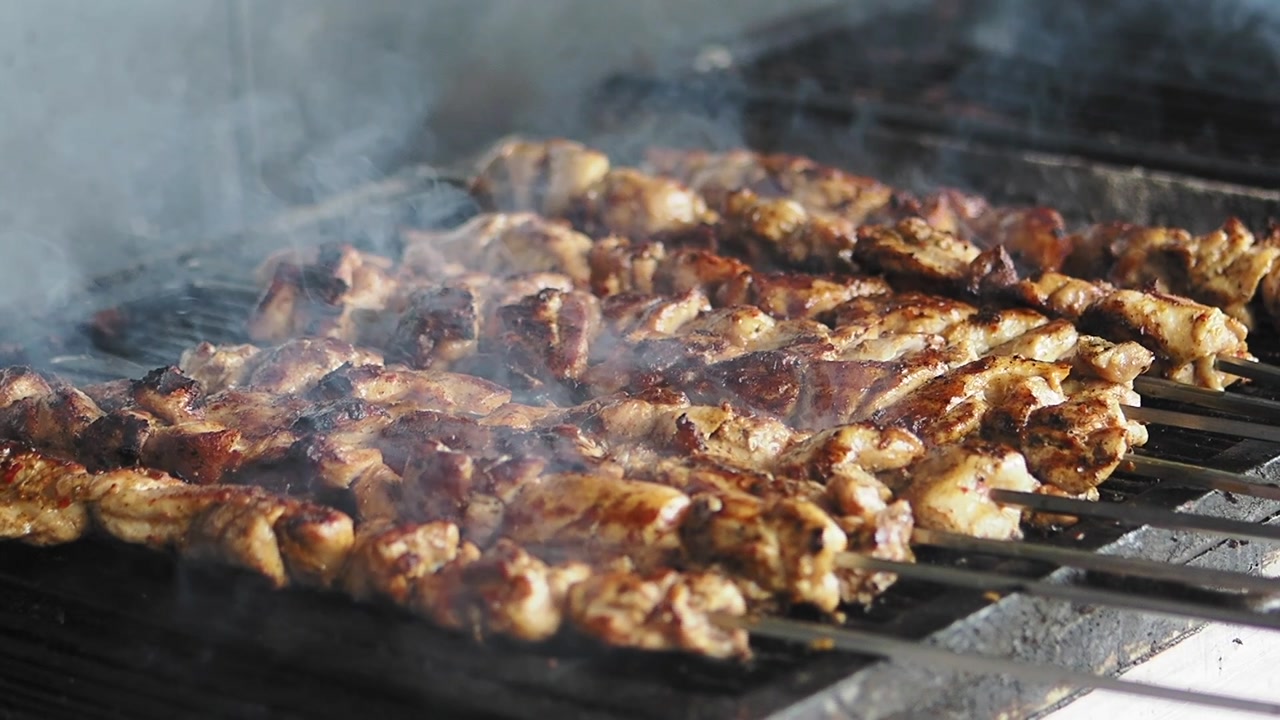 Marinated Meat Skewers Grilling on a Barbecue with Rising Smoke