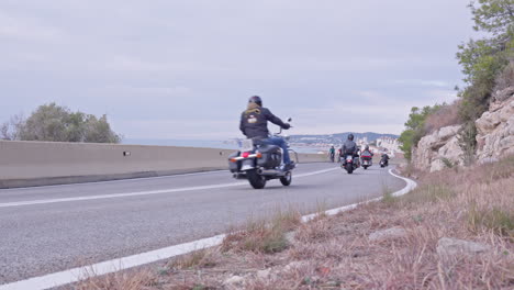 a gang of motorcyclists ride winding road as they head towards the coastal city