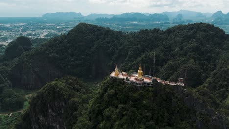 templo de la cueva del tigre en lo alto de una montaña verde exuberante con un telón de fondo panorámico