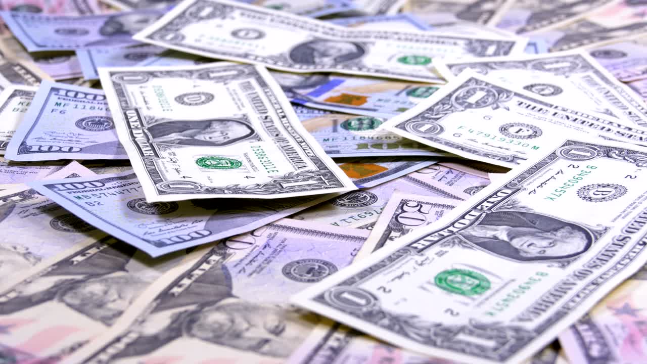 billetes de dólares estadounidenses de diferentes denominaciones caen sobre la mesa