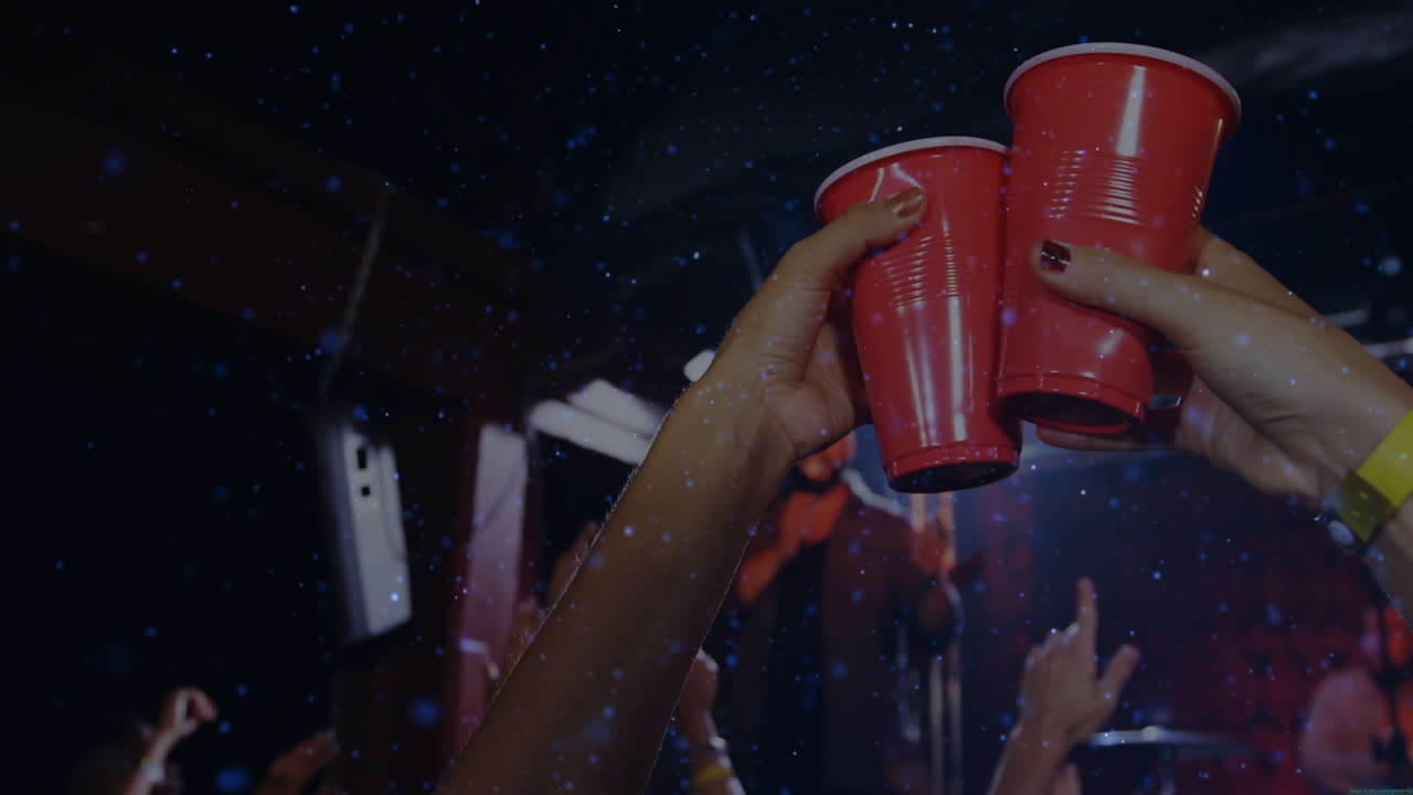 Friends raising red cups in dark club, showing business stats overlay with floating confetti