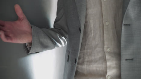 man wearing suit arrives and unbuttons jacket immediately