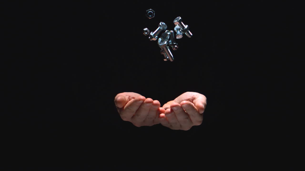 볼트와 나사를 던지는 사람의 손