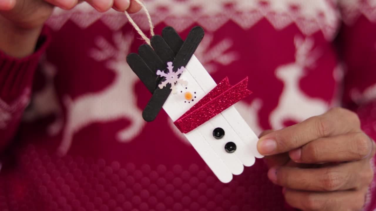 아이스크림 막대로 만든 눈사람을 보여주는 사람