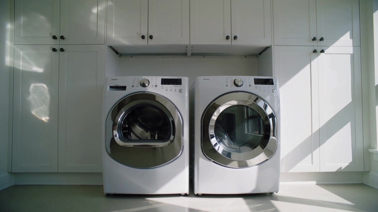 Streaming sunlight from right window creating changing glare on washer and dryer in laundry room