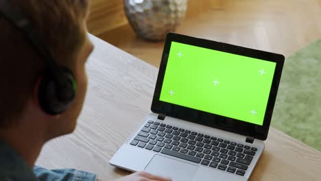 hombre de negocios hablando en video en línea en una computadora portátil con pantalla verde en la oficina. trabajador corporativo llama video en la computadora portatil en la oficina de casa