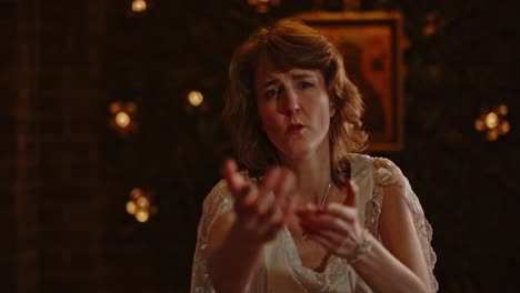 woman in a long white dress sings and dances in a church